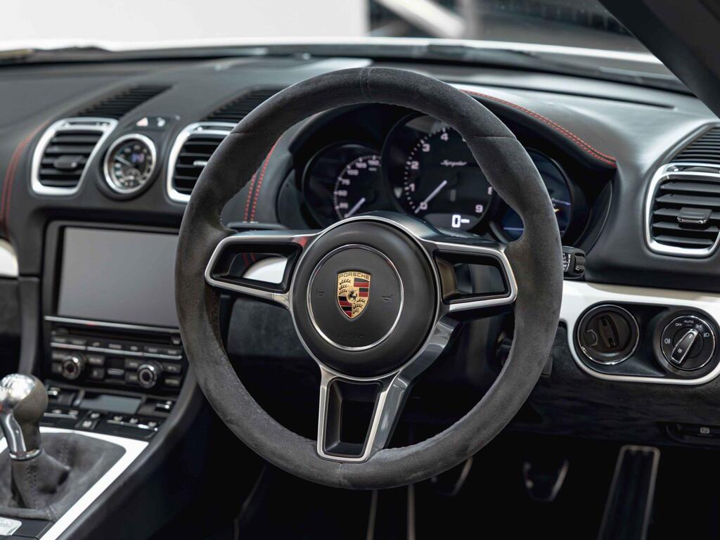 An interior shot of the steering wheel on a 2015 Porsche Boxster