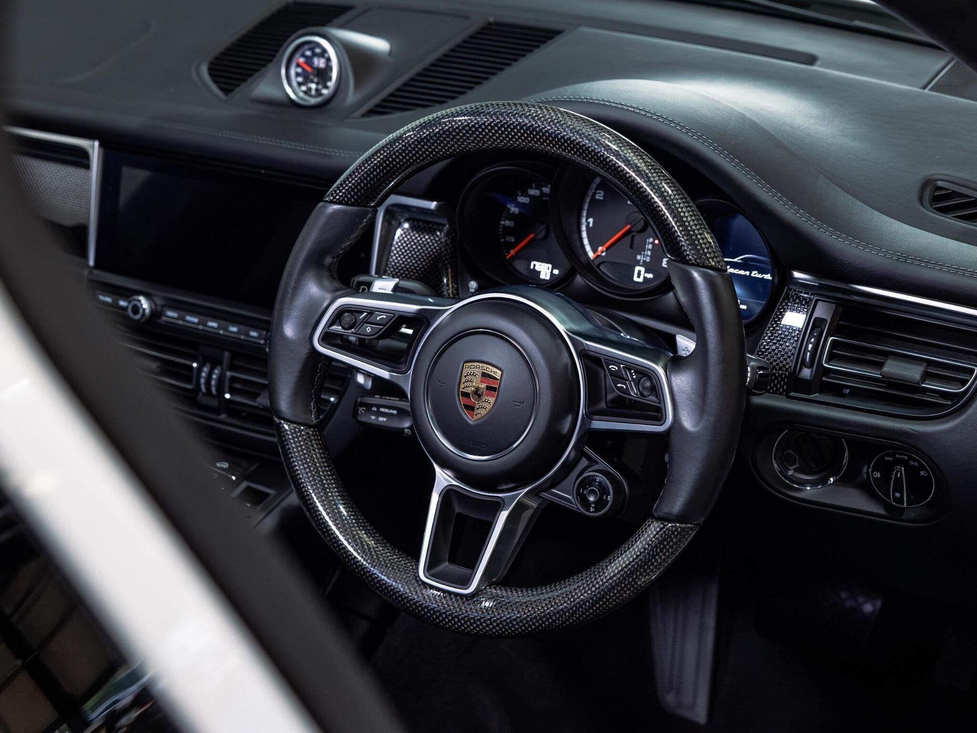 An interior shot of the steering wheel on a 2020 Porsche Macan
